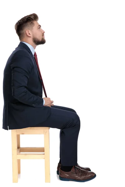 Vista lateral de joven hombre de negocios fijación de corbata en estudio — Foto de Stock