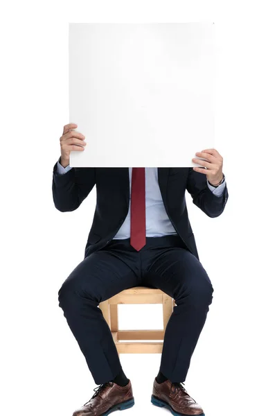 Jovem empresário escondido atrás vazio branco bordo — Fotografia de Stock