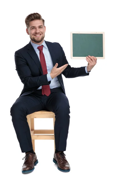 Lycklig ung affärsman som håller en tom svart tavla — Stockfoto