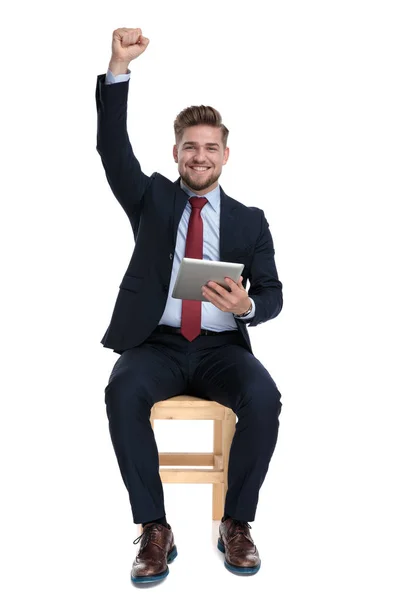 Eccitato giovane uomo d'affari tenendo scheda in studio — Foto Stock