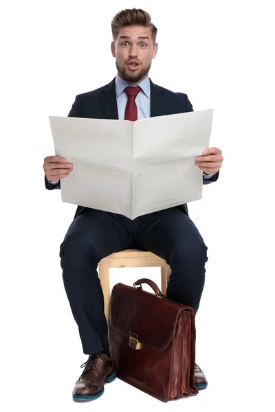 Grappige jonge zakenman lezing nieuws papier op witte achtergrond — Stockfoto