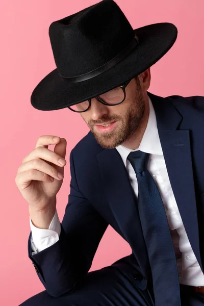 Uomo d'affari seduto e nascondere i suoi occhi sotto un cappello nero — Foto Stock