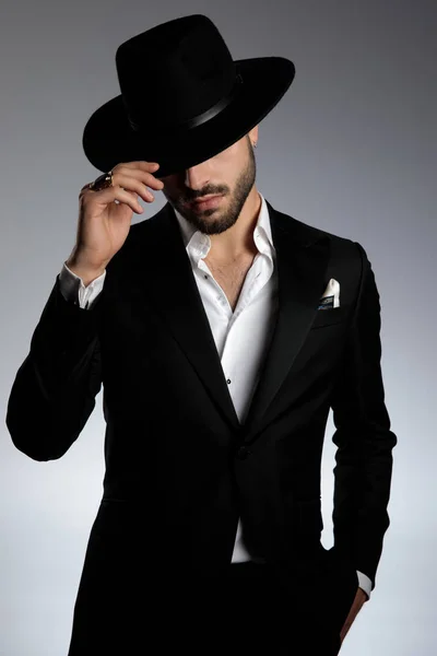 Mysterious young man pulling hat down and saluting Stock Image