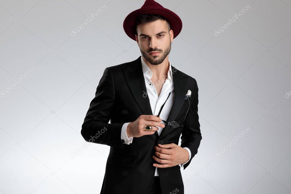 businessman holding his glasses and his jacket's button