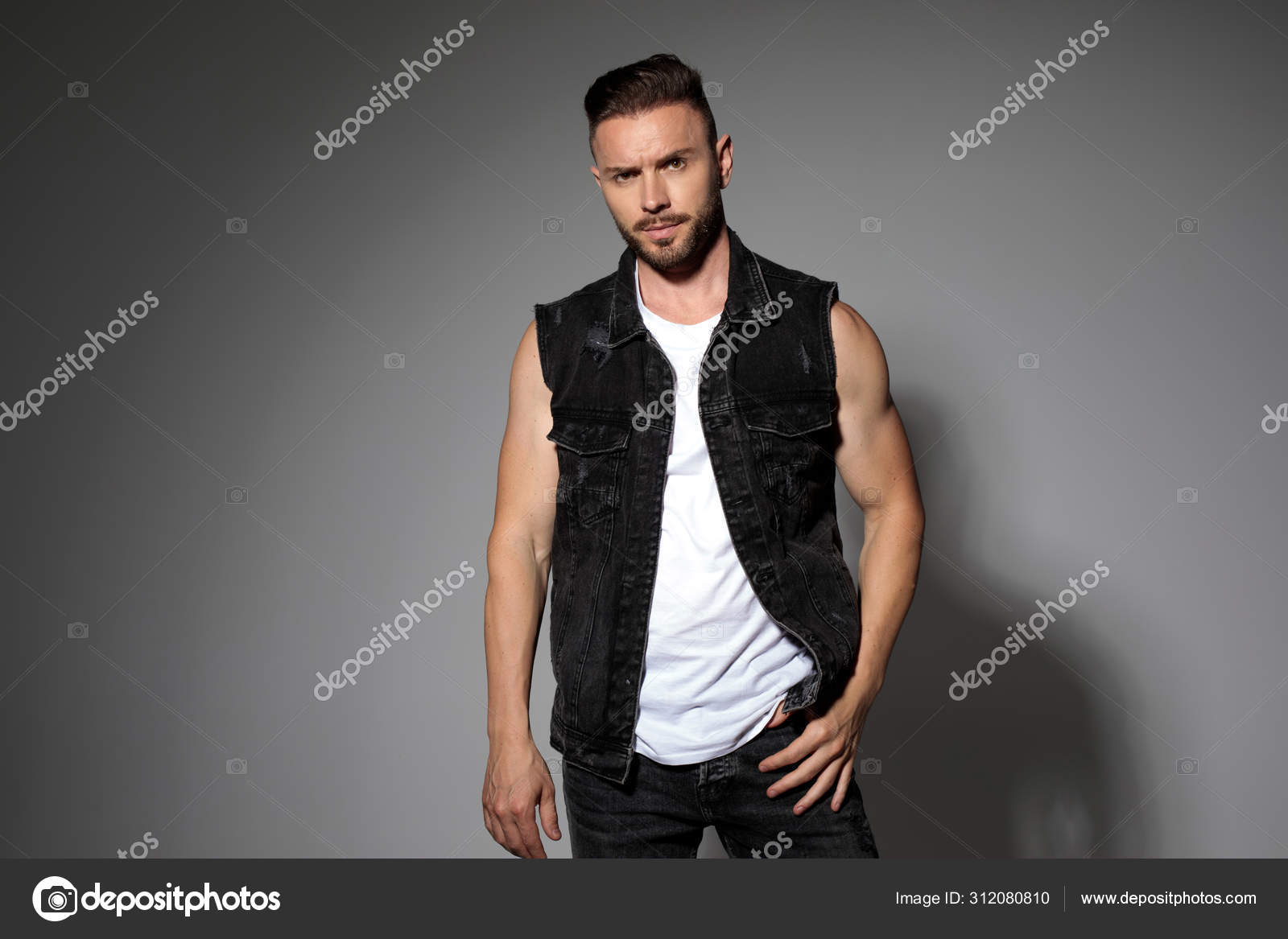 Snooze Kolibrie Kast Determined casual man posing and wearing a black jeans vest Stock Photo by  ©feedough 312080810