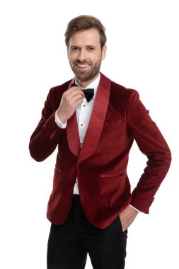 Kırmızı kadife smokin giyen mutlu moda adamı