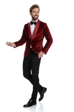 Kırmızı kadife smokin giyen mutlu genç moda adamı