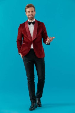 Kırmızı kadife smokin giyen mutlu moda adamı