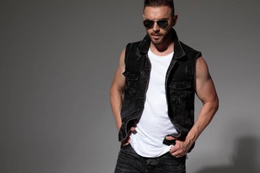 Sert adam iki eli ceplerinde poz veriyor. 