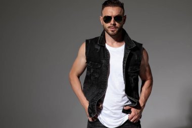 İki elini de cebinde tutan kendinden emin genç bir adam. 