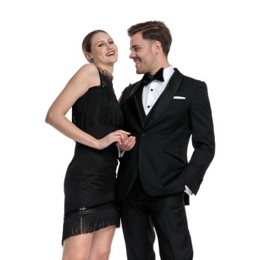 Neşeli sıradan bir çift el ele tutuşup gülüyor. 