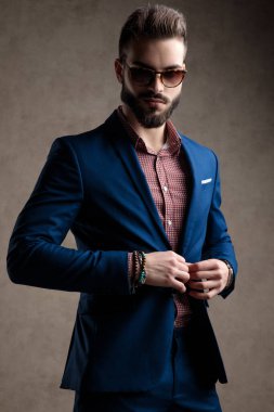 İş adamı ceketinin düğmesini tutuyor. 