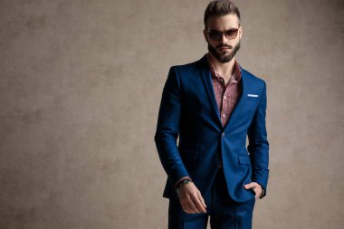 Bir eli cepte olan işadamı ayakta duruyor