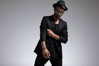 Sıradan bir adam dikilip kollarını düzeltiyor.