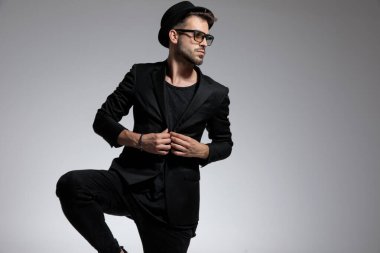 Sıradan bir adam ayakta duruyor ve ceketini düzeltiyor.