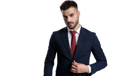 Yakışıklı genç işadamı ceketinin düğmelerini açıyor. 