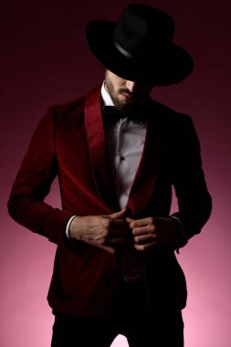 Kırmızı kadife smokin ayarlayan kendine güvenen bir manken.