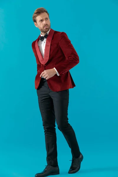 Homem de moda elegante vestindo smoking de veludo vermelho e andando — Fotografia de Stock