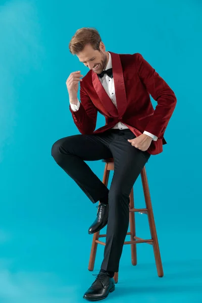 Homem elegante feliz vestindo smoking de veludo vermelho e sorrindo — Fotografia de Stock