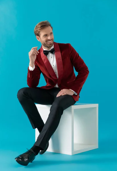 Lächelnder eleganter Mann im roten Samt-Smoking und mit Blick auf sid — Stockfoto