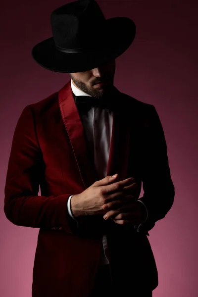 Misterioso giovane uomo di moda che indossa uno smoking di velluto rosso — Foto Stock