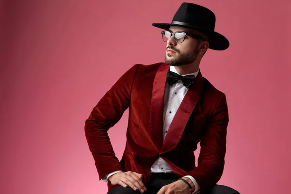 Joven hombre de moda con esmoquin de terciopelo rojo y mirando a un lado —  Fotos de Stock