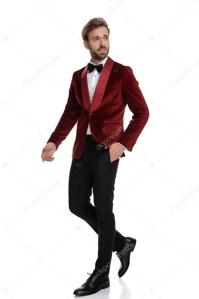 fashion man wearing red velvet tuxedo and walking