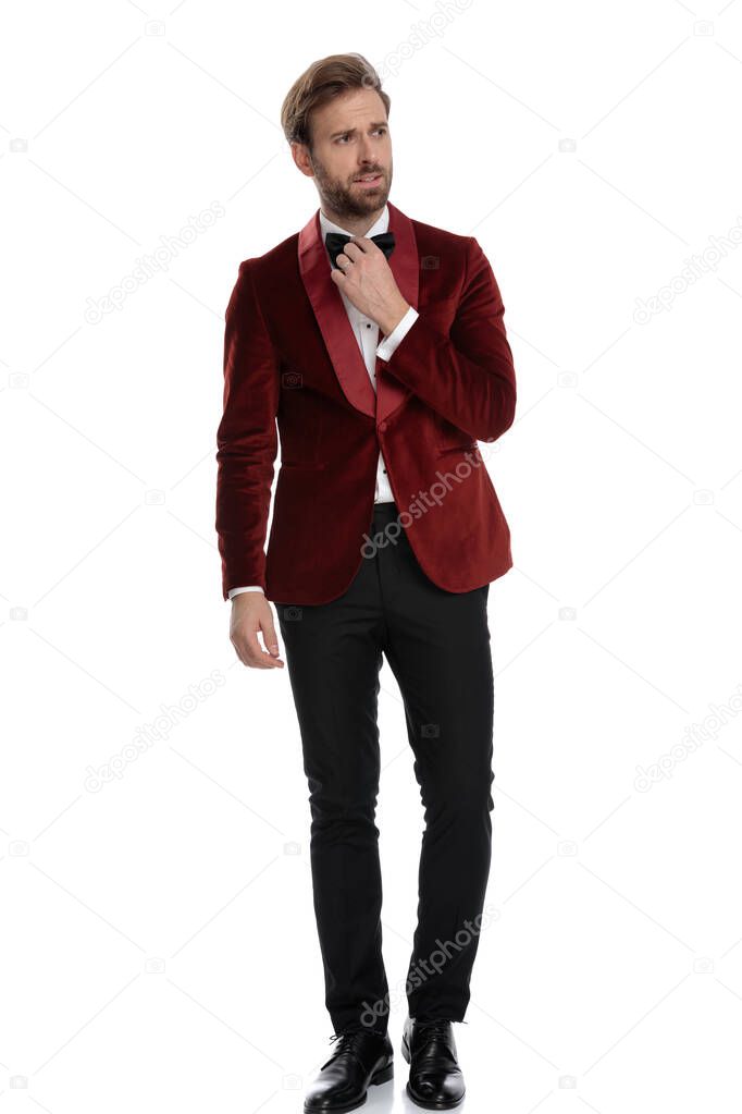 fashion model wearing red velvet tuxedo and fixing bowtie