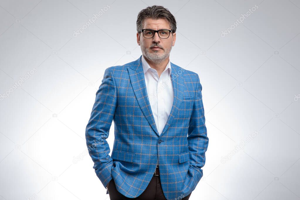 businessman standing with hands in pocket and looking at camera