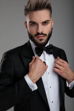 Damat tasmasını düzeltiyor. 