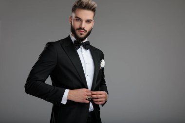 Kendine güvenen damat ceketinin düğmelerini açıyor.