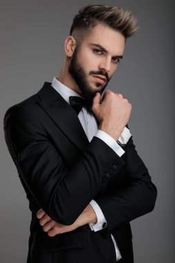 Damat eli çenesinde düşünürken emin olamıyor.