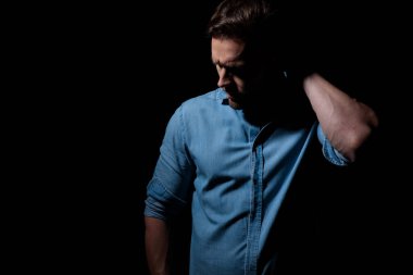 Ayakta duran ve kafasını kaşıyan sıradan bir adam.