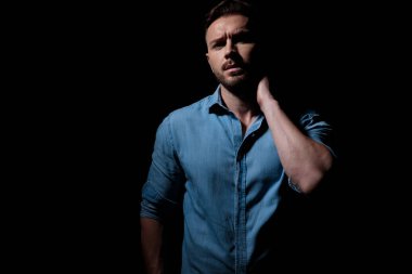 Ayakta duran ve yüzünü gölgelerden belli eden sıradan bir adam.