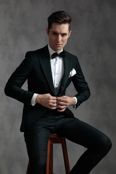 Joven elegante hombre con esmoquin y abrigo arreglado — Foto de Stock