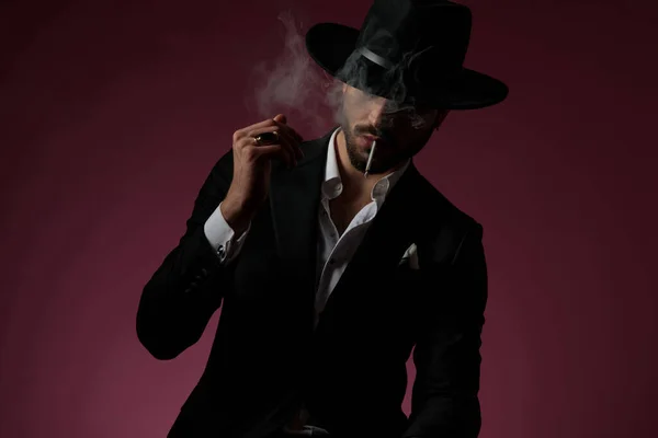 Hombre confiado mirando hacia otro lado, fumando y pensando — Foto de Stock