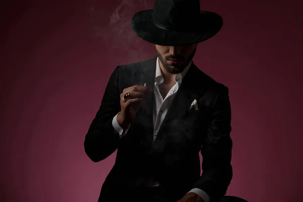 Sérieux homme mystérieux qui fume une cigarette — Photo