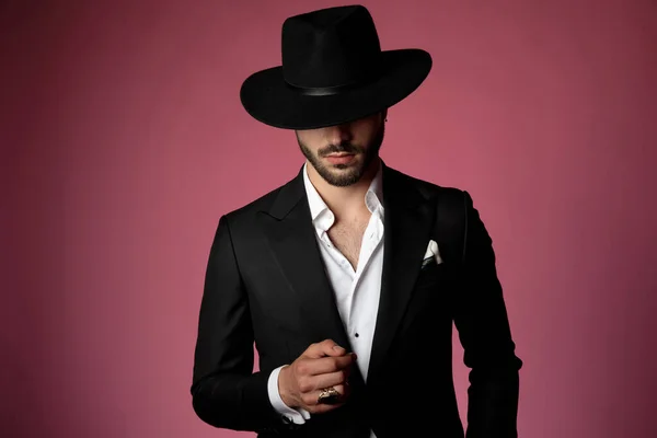 Hombre serio vistiendo un traje negro y sombrero — Foto de Stock