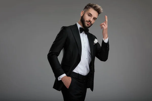 Serious looking groom holding a fired finger gun — Stock Photo, Image