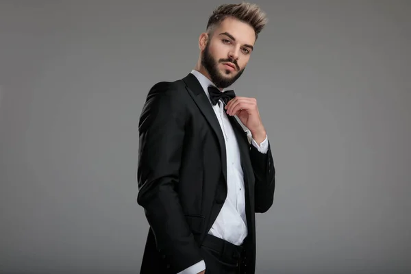 Charming groom adjusting his bowtie — Stock Photo, Image