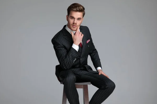 Young fashion model wearing double breasted suit and thinking — Stock Photo, Image