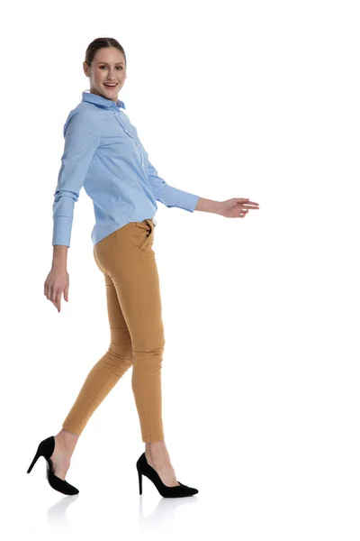 Genç iş kadını mavi gömlek giyiyor ve yürüyor. — Stok fotoğraf
