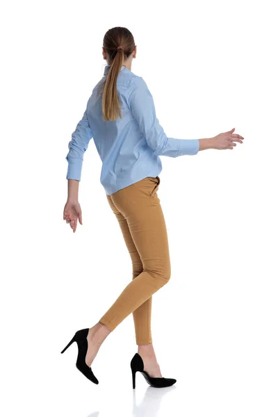 年轻的女商人穿着蓝色衬衫走路 — 图库照片