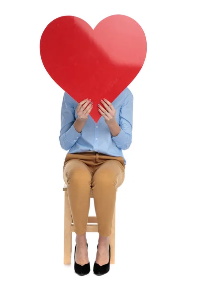 Бізнес-леді ховається обличчям за великим червоним серцем — стокове фото