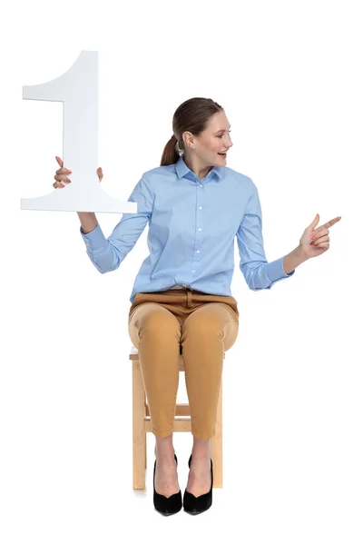 Young businesswoman holding number one sign — Stock Photo, Image