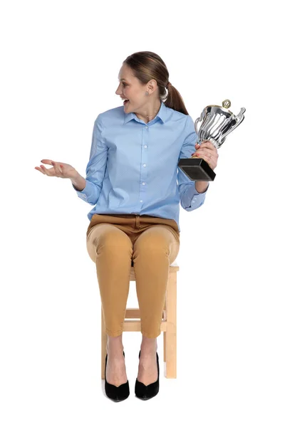 Happy businesswoman holding trophy and talking — Stock Photo, Image