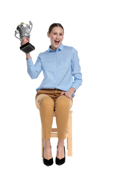 Proud young woman holding trophy and smiling — Stock Photo, Image