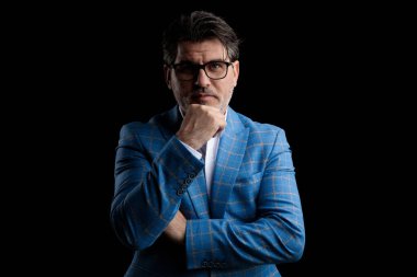 Çenesi ciddi bir şekilde ayakta duran iş adamı.