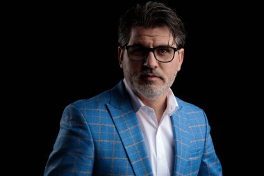 İş adamı kameraya ciddi ciddi bakıyor.