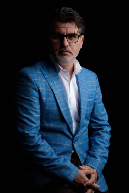 İş adamı ayakta durup kameraya bakarken el ele tutuşuyor.